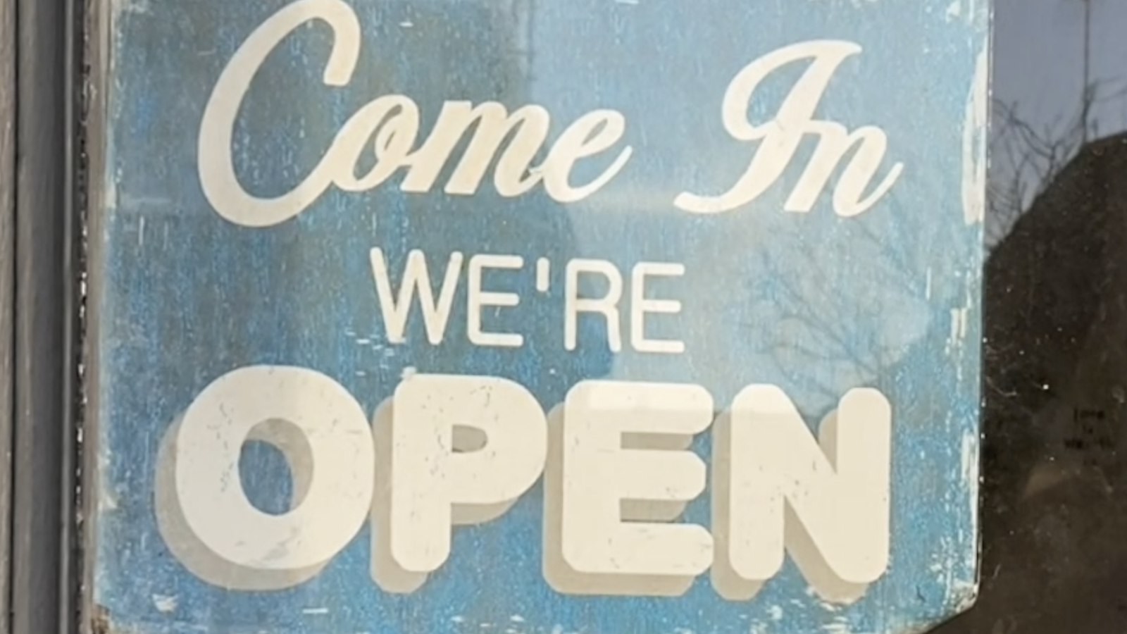 A shop door showing a sign turned to say we are open
